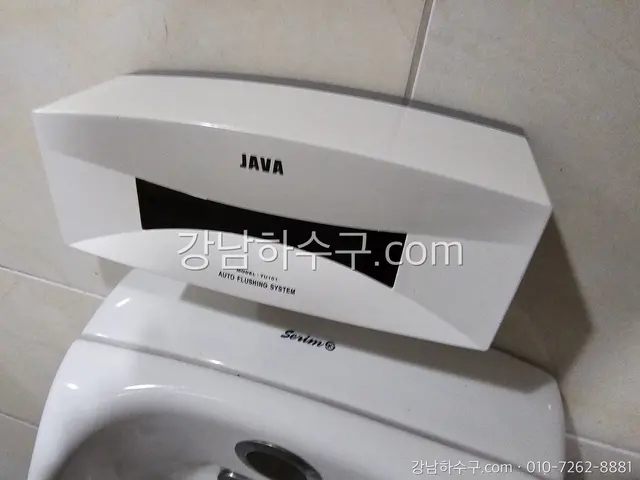 소변기 위에 달린 자동 센서 플러시 유닛 근접