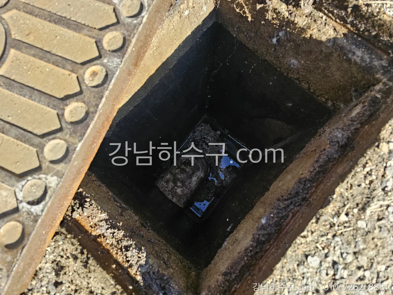 주차장 트렌치 그레이팅 아래 배수 홈에 쌓인 흙과 기름