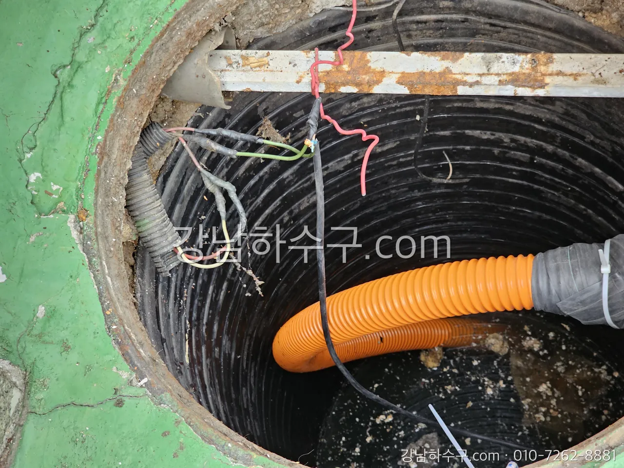 집수정 뚜껑을 열고 호스로 바닥 슬러지를 걷어내는 작업