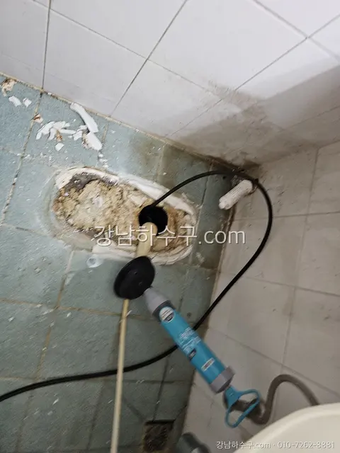 변기를 탈거한 뒤 바닥 플랜지와 배수구 상태를 점검하는 작업